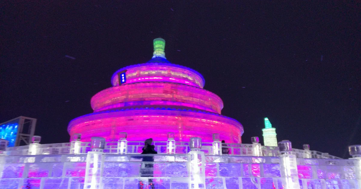ประติมากรรมน้ำแข็งทรงกลมประดับไฟสีชมพูในงานเทศกาลน้ำแข็งฮาร์บิน Harbin Ice and Snow World ยามค่ำคืน