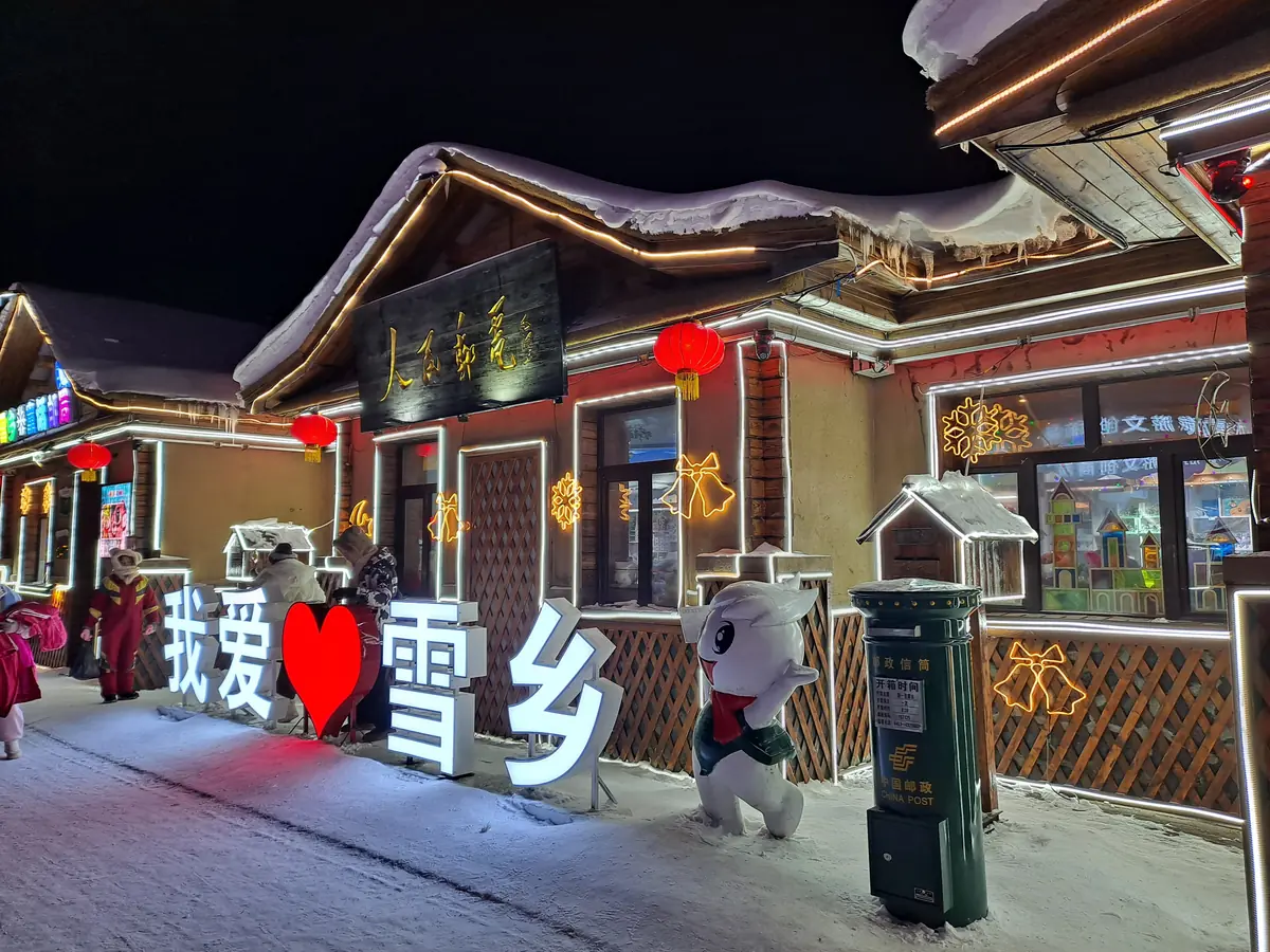 ที่ทำการไปรษณีย์ในหมู่บ้านหิมะ Snow Town (雪乡) ประดับไฟยามค่ำ หลังคาปกคลุมด้วยหิมะ